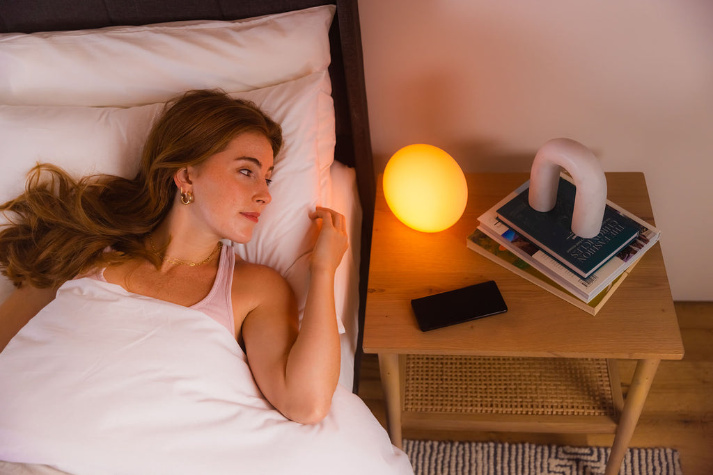 woman in bed next to blissradia smart ambient mood light