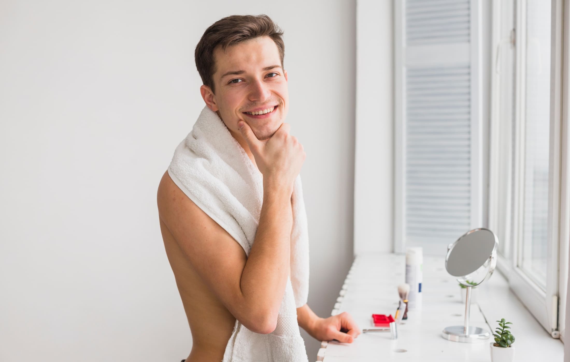 A man touches his chin thoughtfully, showcasing his clean, fresh face. His expression reflects consideration of his combination skin type as part of his skincare routine. The image highlights the importance of knowing your skin type to maintain a healthy and balanced men's skincare routine.