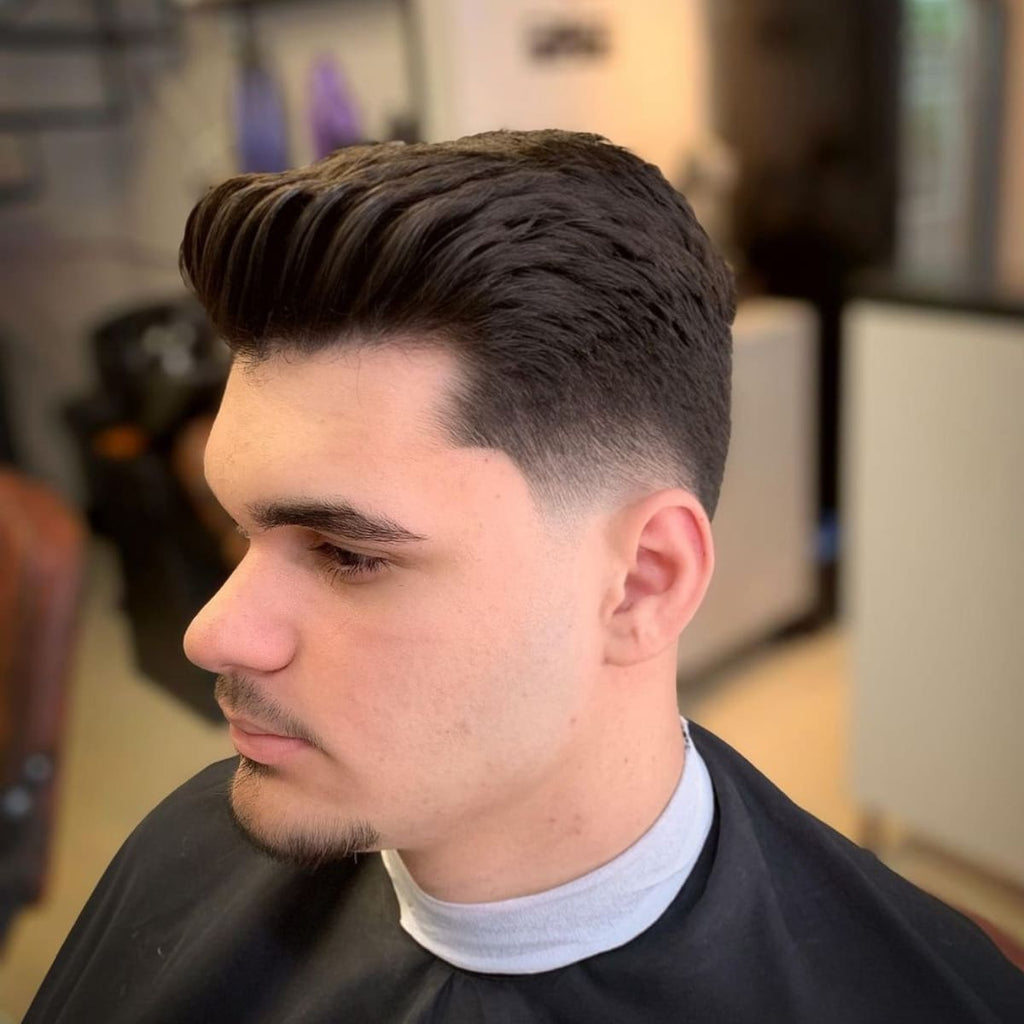 Side profile of a classic low fade quiff hairstyle with a clean fade around the ears and voluminous top. Perfect example of a low fade quiff for men, featuring a sharp, polished look suitable for various face shapes and occasions."